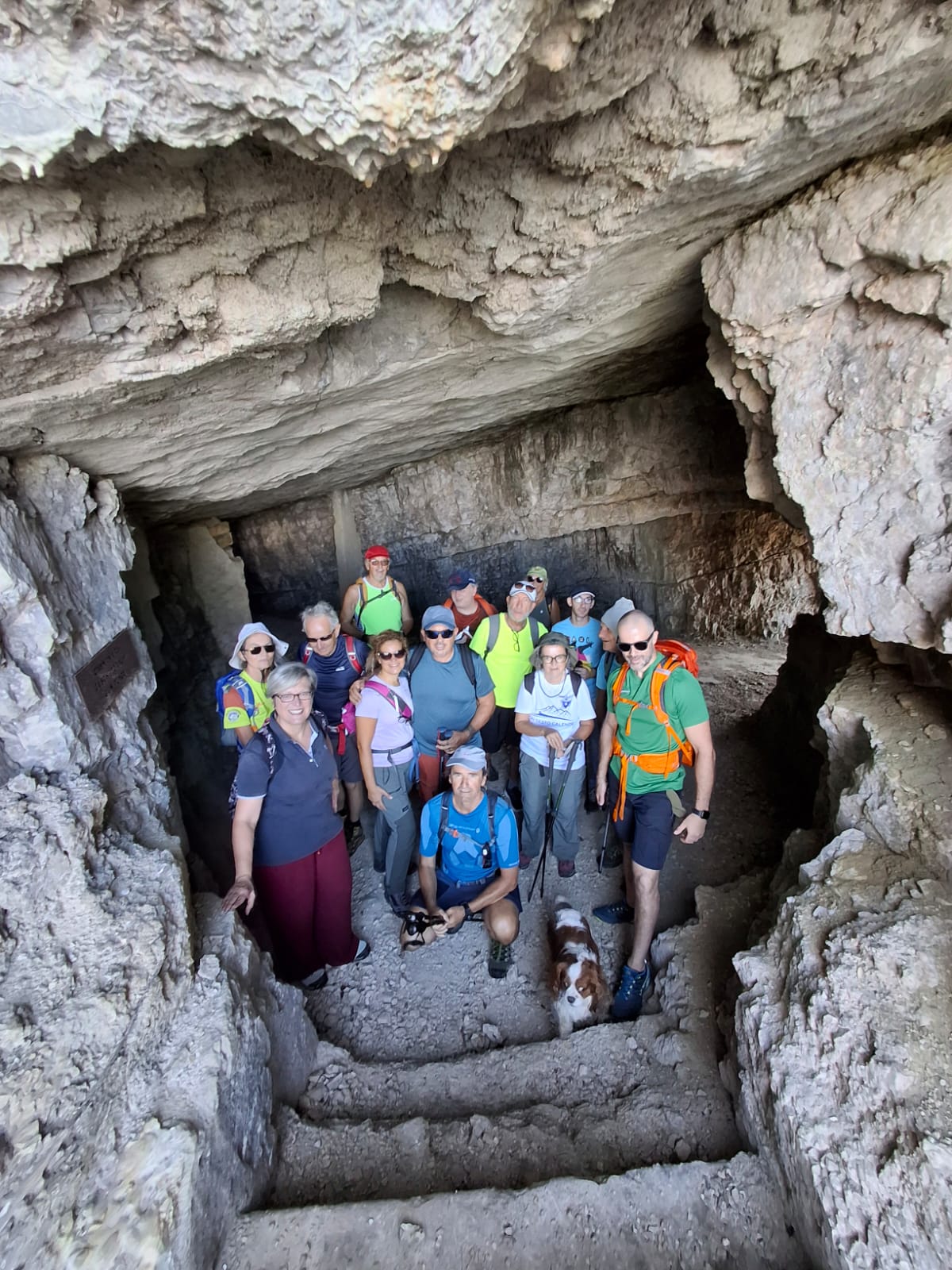 I soci del CISV posano insieme all’interno di una grotta, circondati dalla roccia e immersi nell’atmosfera suggestiva della montagna.