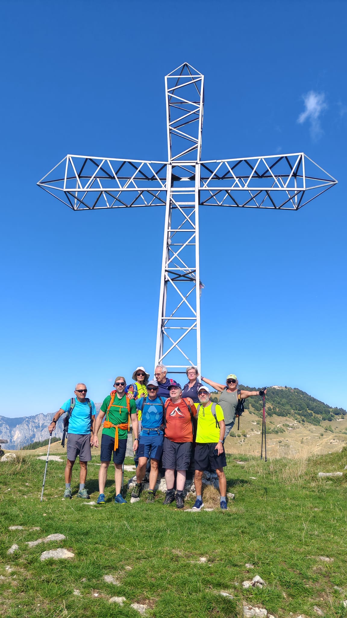 I soci del CISV posano insieme sotto una caratteristica croce di ferro, immersi nel paesaggio montano, al termine di un’escursione condivisa tra natura, fatica e soddisfazione.